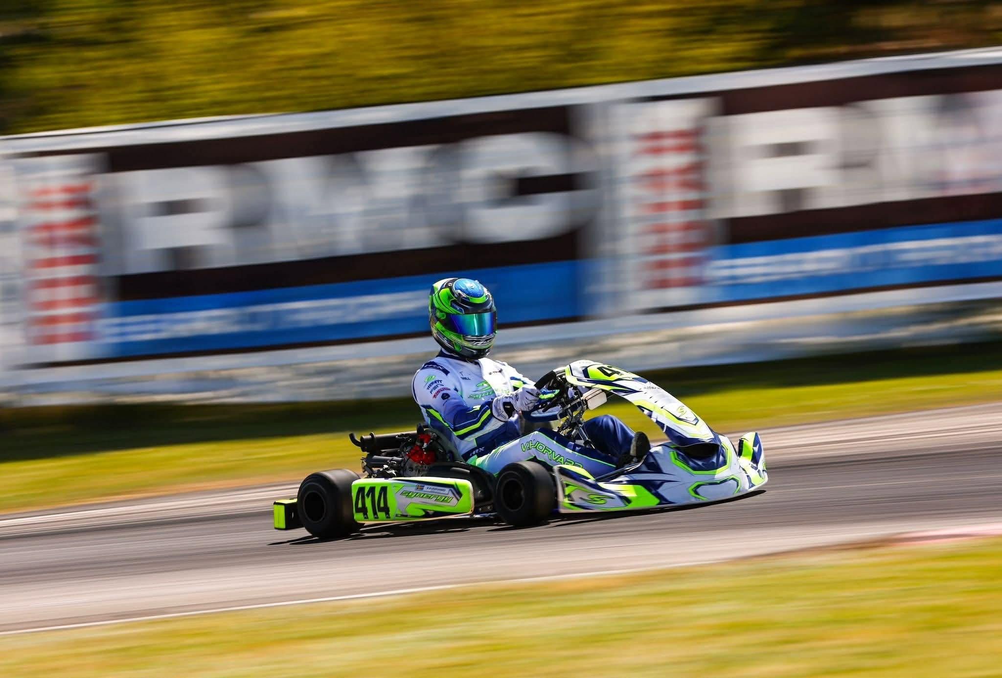 Synergy kart number 414 at speed at the Rotax Euro Trophy, panned against a blurred advertising barrier